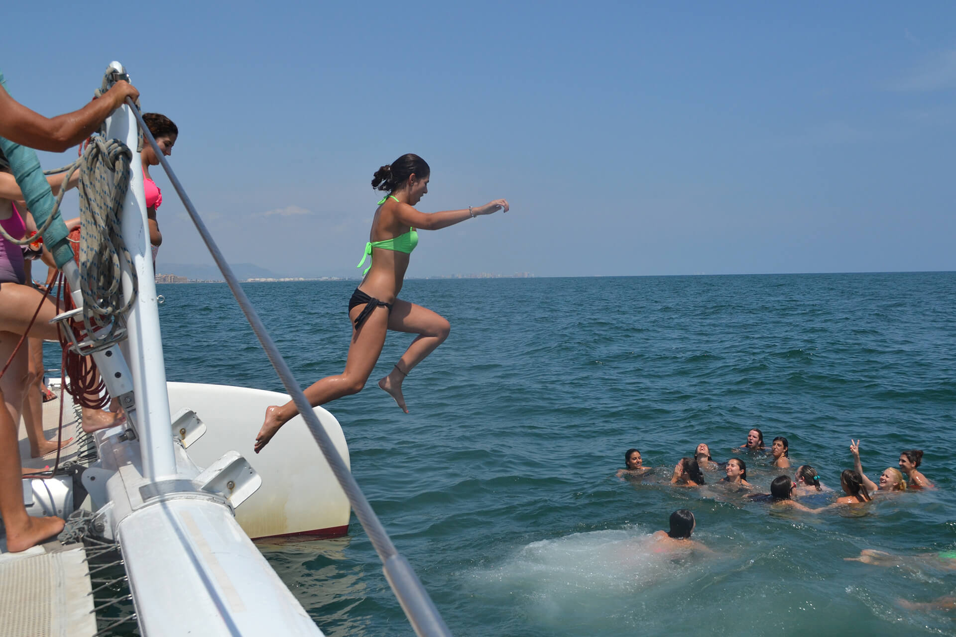 Chica saltando al mar desde un catamarán durante una boat party en Valencia