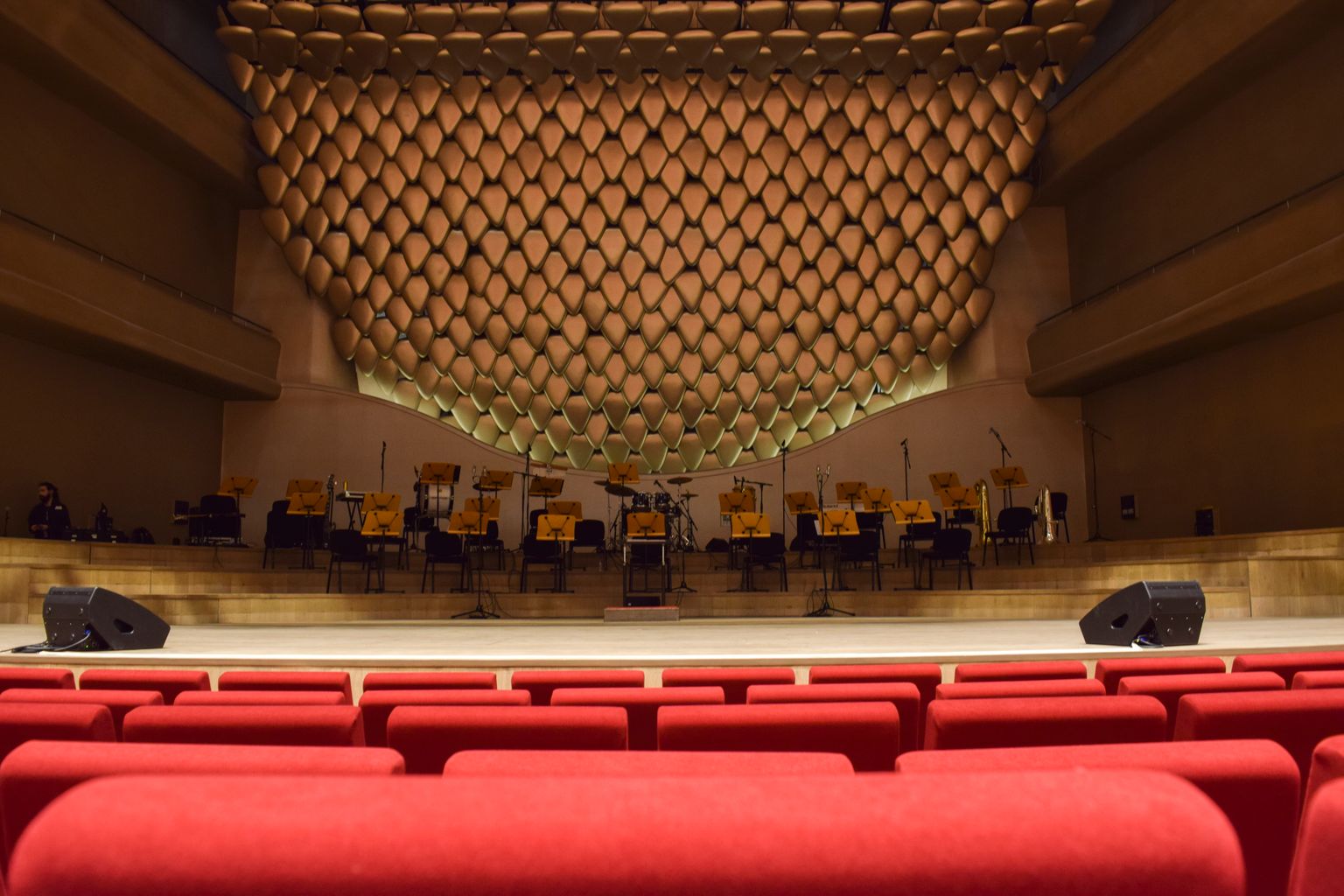 Interior elegante de una sala de conciertos con butacas vacías y escenario, como las salas del Palau de la Música de Valencia