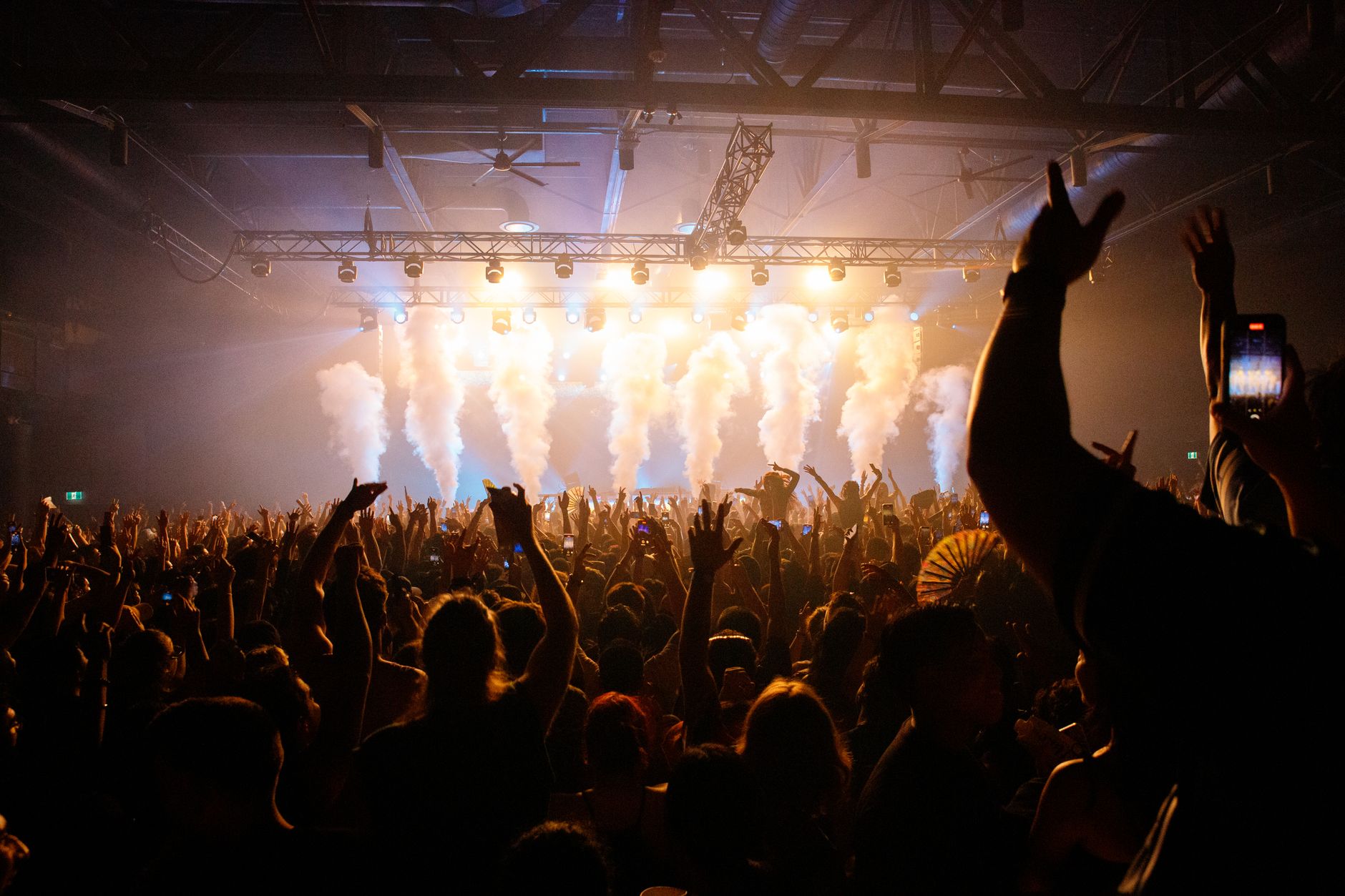 Público disfrutando de un concierto en una sala con luces de escenario