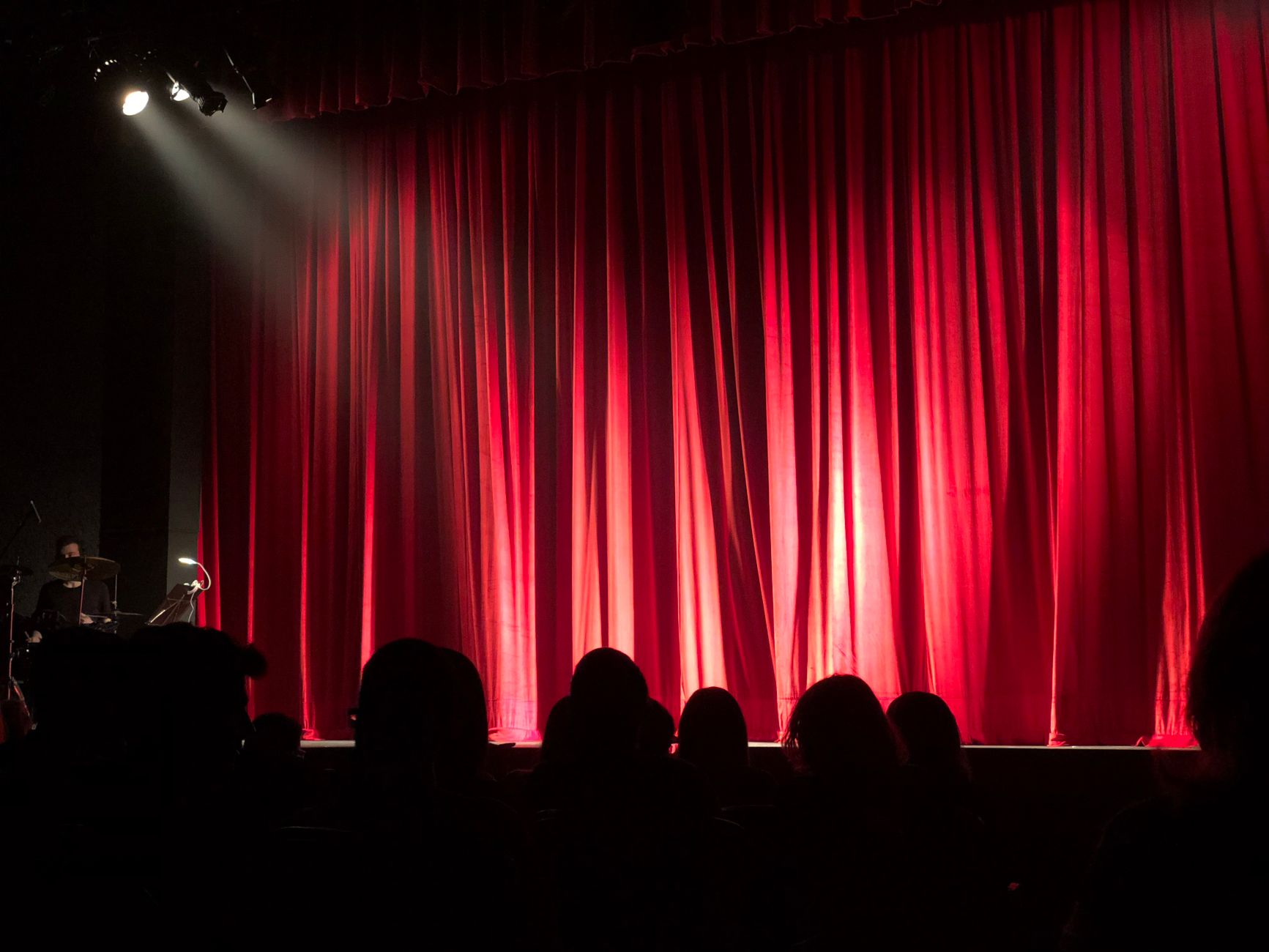 Escenario de teatro con cortinas rojas y focos