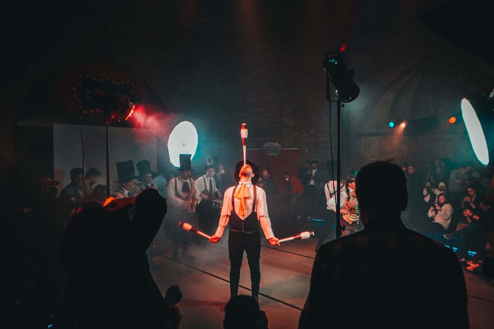 Malabarista actuando bajo luces de escenario durante un espectáculo de circo