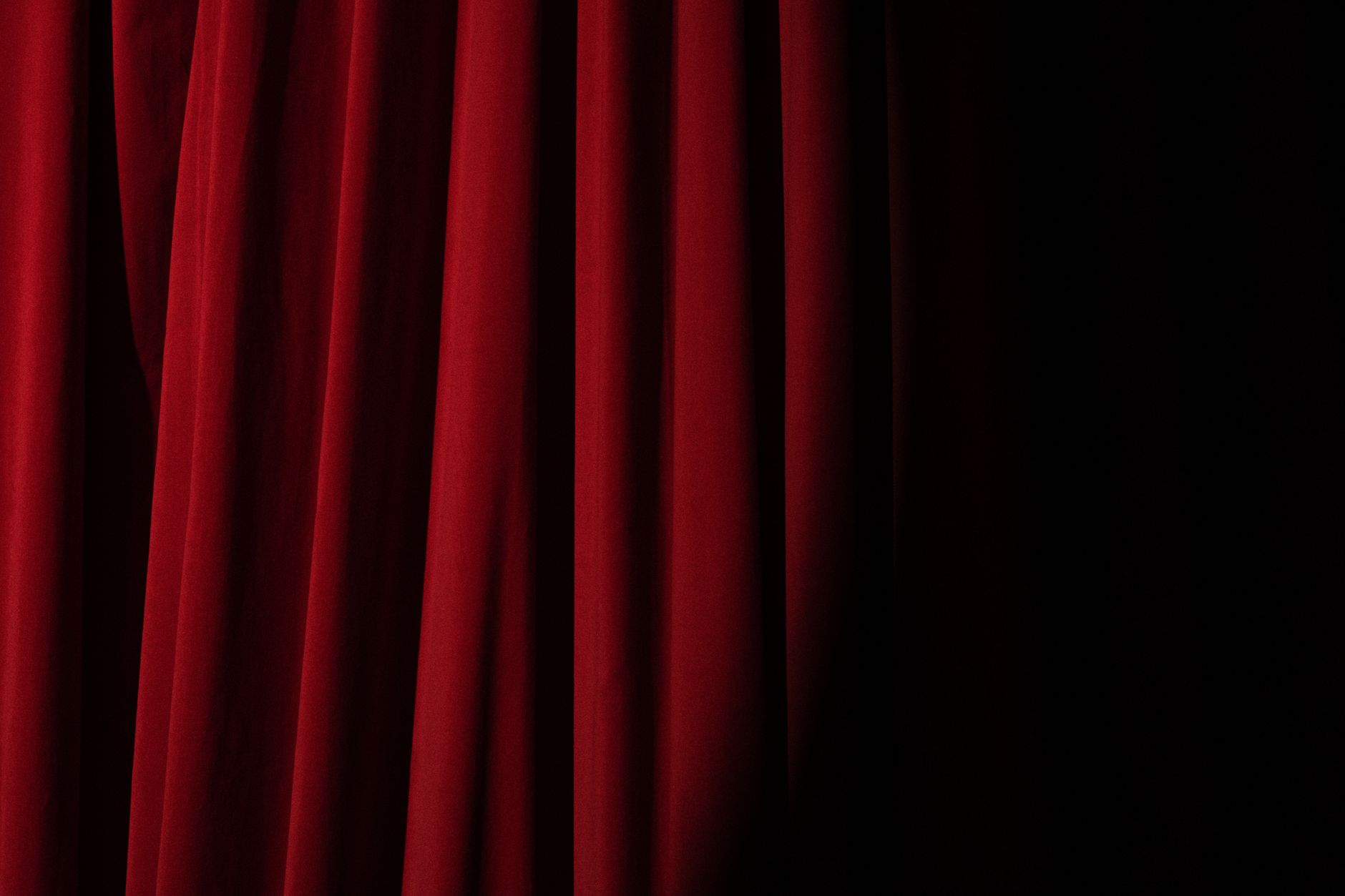 Cortinas rojas de teatro con iluminación dramática