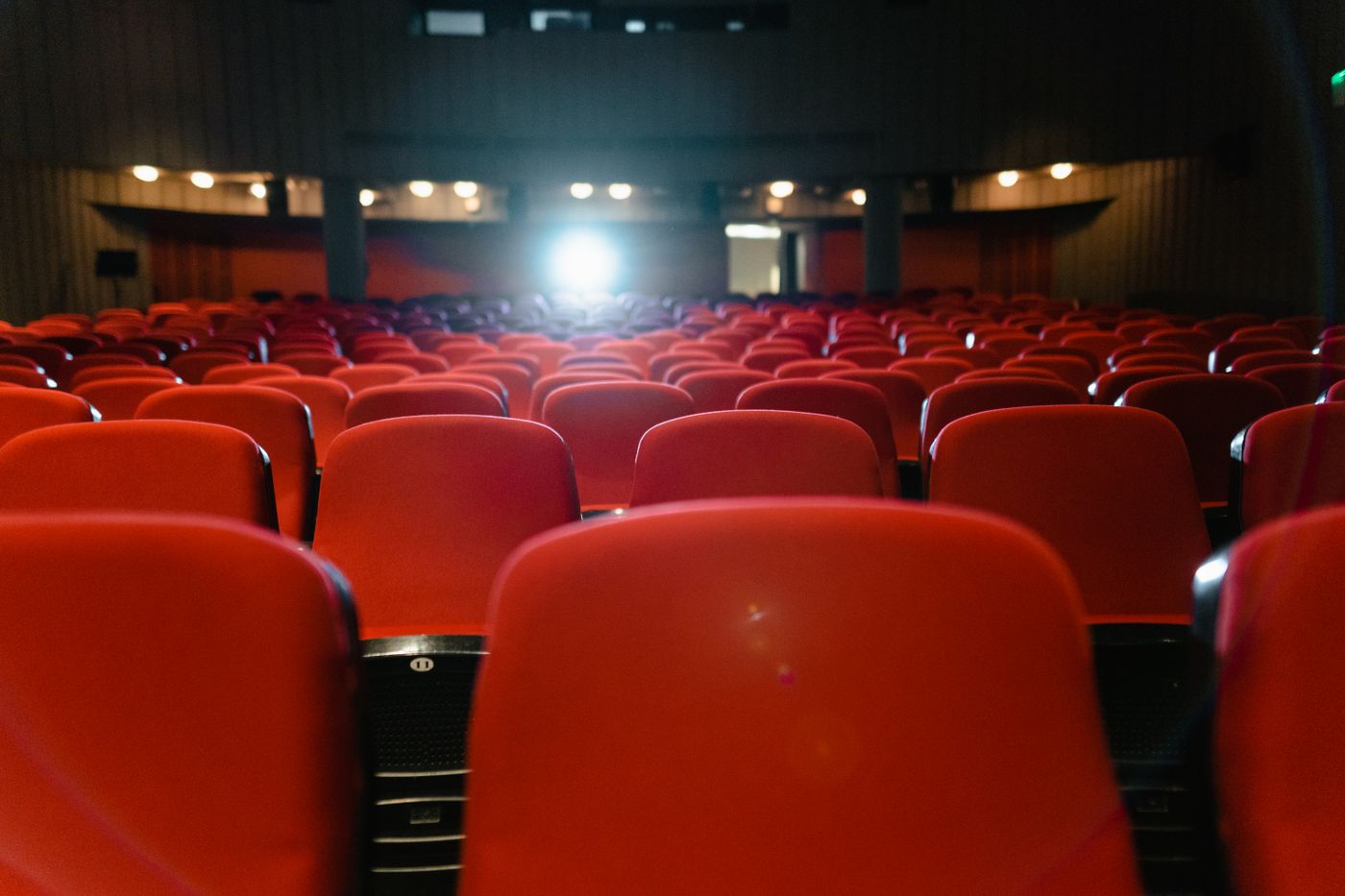 Sala de cine con butacas rojas y público durante una proyección