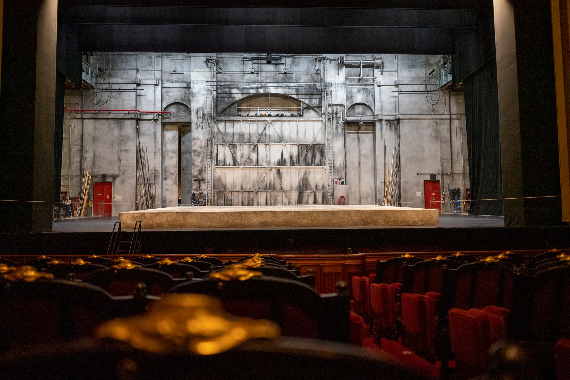 Escenario vacío de un teatro con butacas y telón de fondo