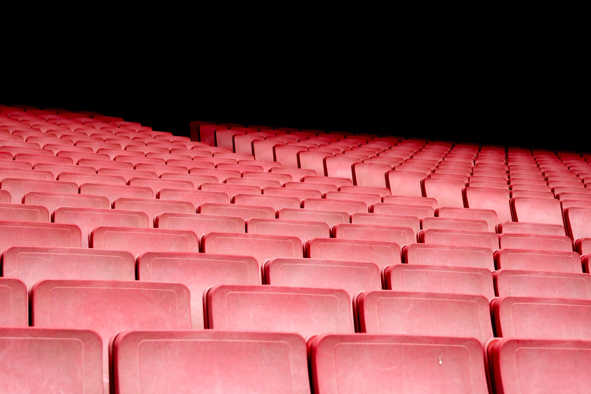 Platea de un auditorio con butacas rojas e iluminación dramática